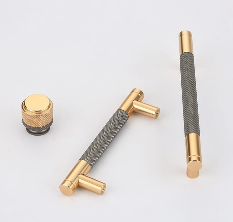 Möbelgriff Laure – goldener Leistengriff mit passendem Knopf und gerändelter Industrial-Oberfläche. Als Knopf sowie in 96, 128 und 256 mm erhältlich, ideal für Küchen-, Bad- und Büromöbel, Schränke und Schubladen – egriffe.at
