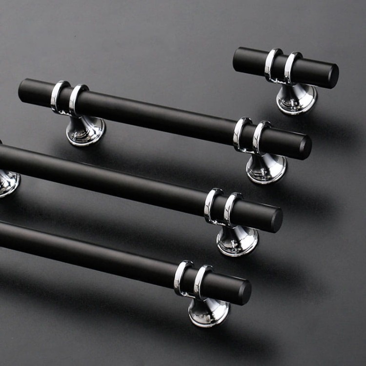 Uchwyt meblowy Pina – elegancki T-Bar z dekoracyjnymi wspornikami w zestawieniu czerni ze złotem lub chromem, dostępny jako gałka i w rozmiarach 96 / 128 / 160 mm, idealny do szaf, komód i drzwi przesuwnych