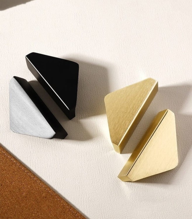 Möbelgriff Isa – asymmetrischer Dreiecksgriff mit markanter geometrischer Form. In gebürstetem Gold oder Schwarz, ideal für Küchenfronten, Kommoden, Vitrinen und Schränke in modernen und glamourösen Interieurs.