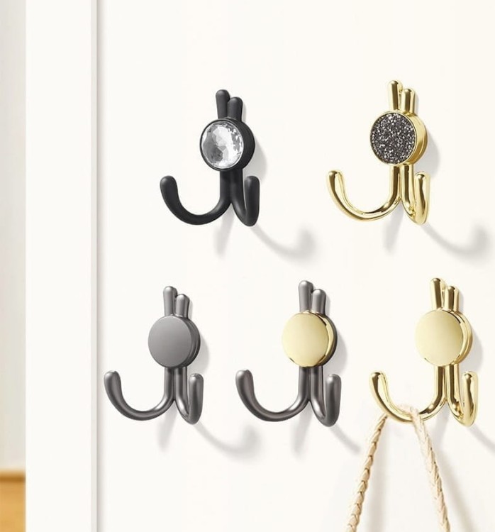 Wandhaken Rosa mit Doppelhaken und dekorativen diamantartigen Enden. Elegant, feuchtigkeitsbeständig, in vielen Gold-, Schwarz-, Silber- und Grautönen erhältlich – für Zuhause und gewerbliche Innenräume.