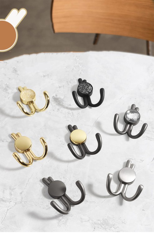 Wandhaken Rosa mit Doppelhaken und dekorativen diamantartigen Enden. Elegant, feuchtigkeitsbeständig, in vielen Gold-, Schwarz-, Silber- und Grautönen erhältlich – für Zuhause und gewerbliche Innenräume.
