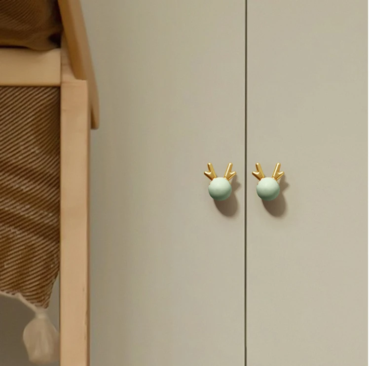 Gałka meblowa Deer – pastelowa kula z dekoracyjnym złotym porożem Dostępna w kolorach: róż, zieleń, błękit, biel Idealna do szuflad, komód i szafek w dziecięcych pokojach w bajkowym, skandynawskim stylu