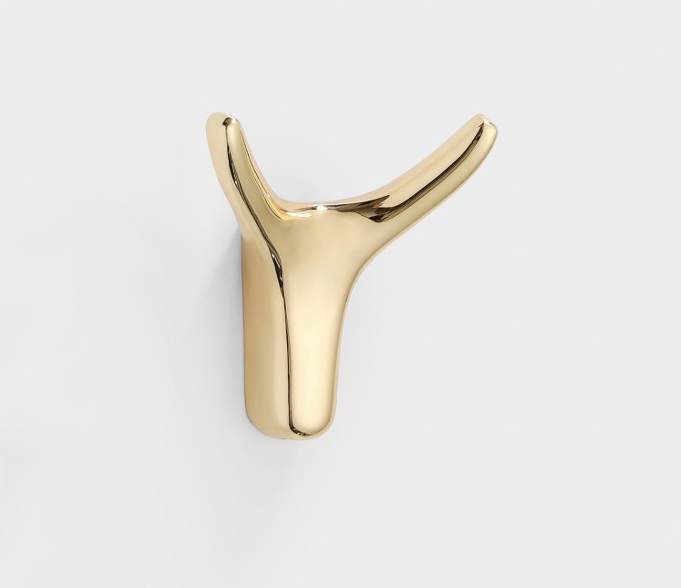 Wandhaken Dorado – moderner Doppelhaken mit eleganter Form, ideal für Jacken, Taschen und Schlüssel. Robust, einfache Montage mit Schrauben im Set. Farben: Gold, gebürstetes Gold, Schwarz und Perlgrau.