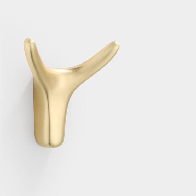 Wandhaken Dorado – moderner Doppelhaken mit eleganter Form, ideal für Jacken, Taschen und Schlüssel. Robust, einfache Montage mit Schrauben im Set. Farben: Gold, gebürstetes Gold, Schwarz und Perlgrau.