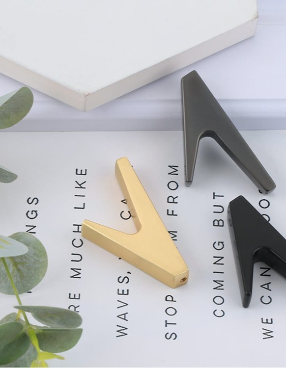 Wandhaken Bola – minimalistischer geometrischer Haken für Zuhause, Büro und Hotels. Aus robustem Metall, einfache Montage mit Schrauben im Set. Farben: Schwarz, Perlgrau und gebürstetes Gold.