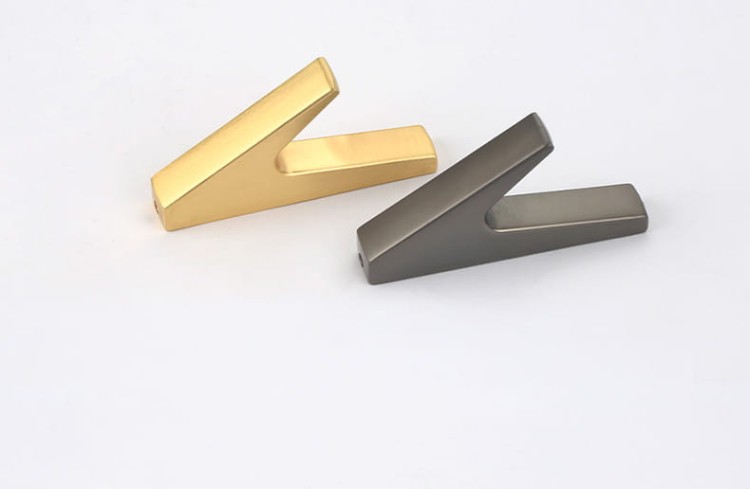Wandhaken Bola – minimalistischer geometrischer Haken für Zuhause, Büro und Hotels. Aus robustem Metall, einfache Montage mit Schrauben im Set. Farben: Schwarz, Perlgrau und gebürstetes Gold.
